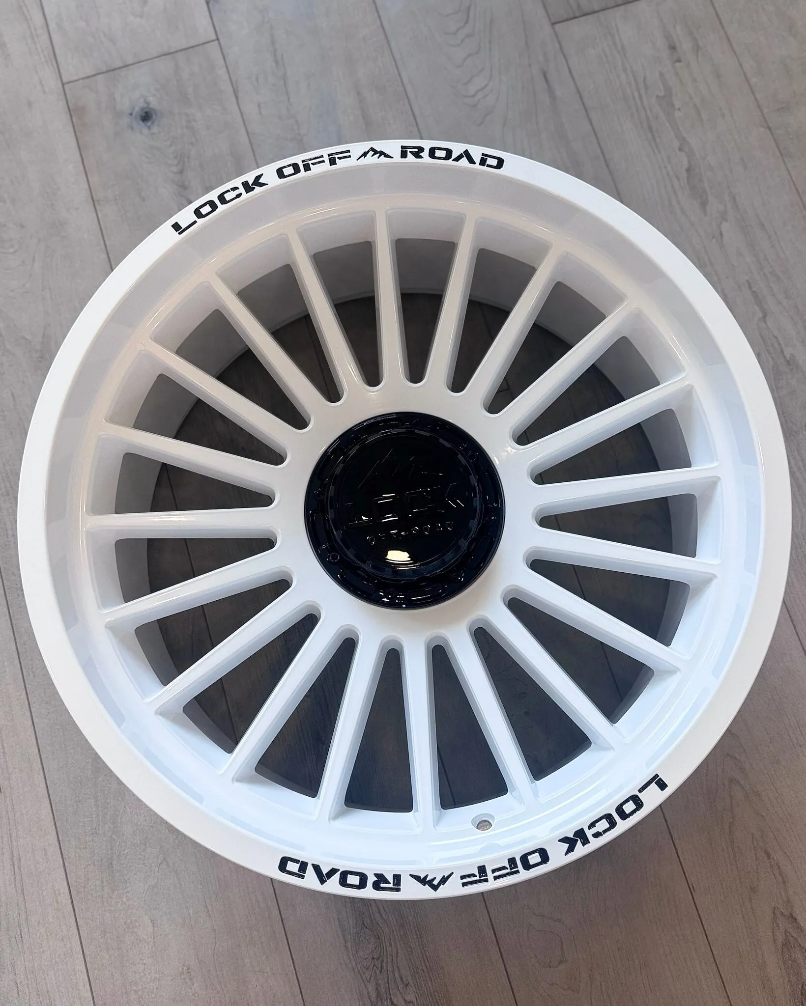 Multi-spoke wheel powder coated white, with a black center